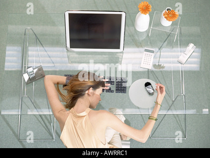 Woman leaning head sur 24 avec des appareils futuristes, high angle view Banque D'Images