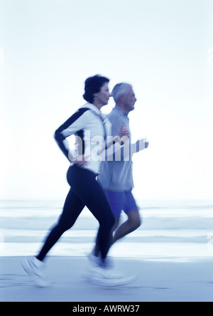 Man and Woman running on beach, side view Banque D'Images