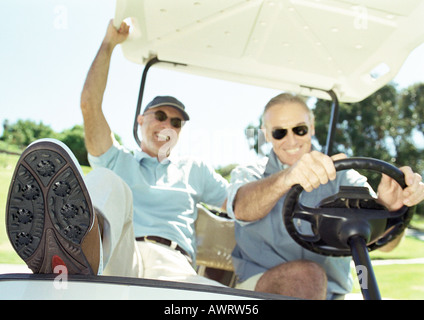 Deux hommes matures in golf cart, smiling, close-up Banque D'Images