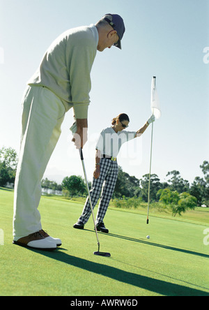 Man putting, woman holding flag Banque D'Images