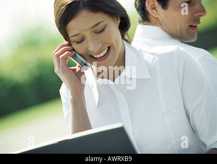 Femme d'affaires et dos à dos, woman using cell phone, la tête et les épaules, de l'inclinaison Banque D'Images