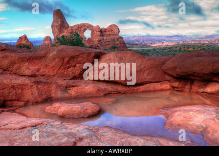 Arches National Park Arch tourelle lever du soleil avec des pierres et de l'eau en premier plan Banque D'Images