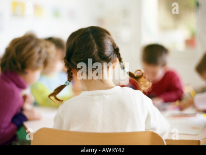 Des enfants assis à table, la tête et épaules Banque D'Images