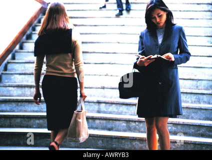 Businesswoman taking notes en face de l'escalier Banque D'Images