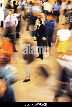 Homme debout toujours en foule, blurred motion Banque D'Images