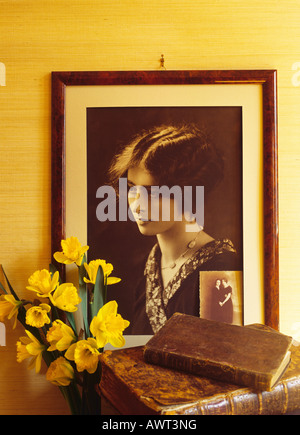 Années 20 vintage portrait encadré d'une jeune femme, jonquilles fleurs et livres anciens Banque D'Images