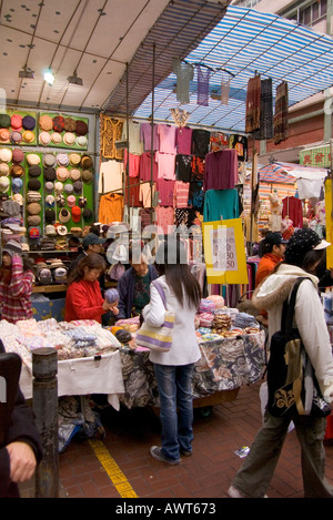 Dh Ladies market Tung Choi Street Mong Kok HONG KONG Femme client au prix de négociation de décrochage en tissu shopping alley Banque D'Images