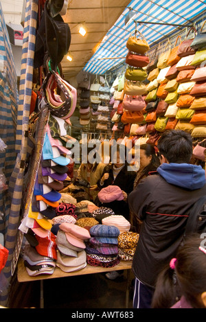 Dh Ladies market Tung Choi Street Mong Kok HONG KONG clients femme shopping pour décrochage chapeaux shop kowloon Banque D'Images