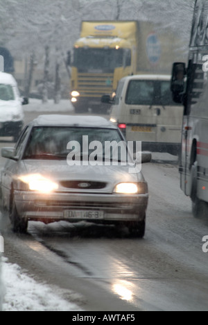 Vehicles Driving on a Snow and Ice Covered European Road in Winter Banque D'Images