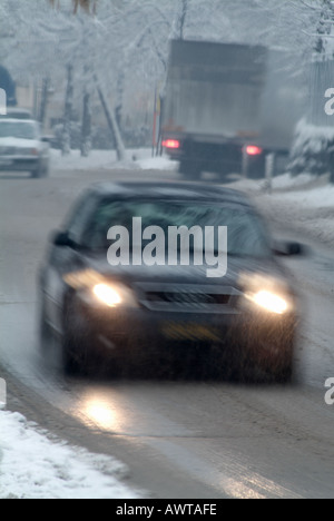 Voiture roulant sur une route couverte de neige et de glace pendant un blizzard de l'hiver en Europe. Banque D'Images