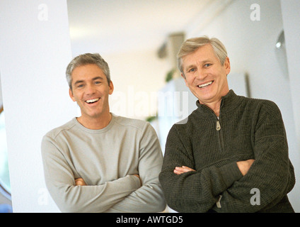 Hommes debout à côté de l'autre bras, rire, portrait Banque D'Images