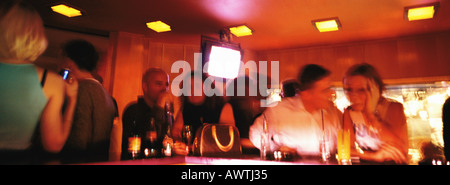Les gens se tenant au bar en discothèque, blurred Banque D'Images