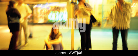 Les gens qui attendent à l'arrêt de bus de nuit, blurred Banque D'Images