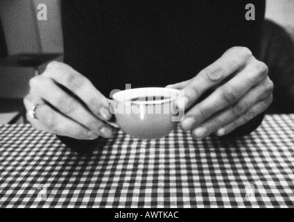 Hands holding cup, close-up, b&w Banque D'Images