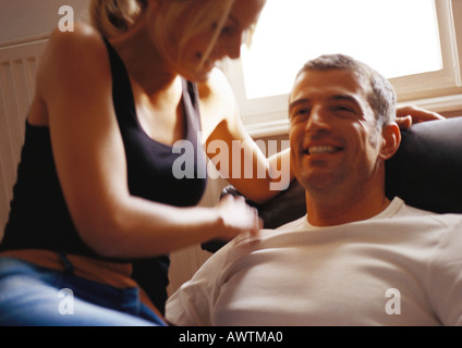 Femme regardant homme assis, de rire. Banque D'Images