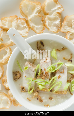 Congee, porridge de riz chinois dans une cuvette entourée de Yu Jie, ou de la pâte à pain bâtons ; Banque D'Images