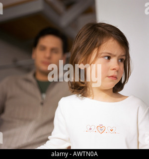 Petite fille à l'écart, la tête et les épaules, close-up, l'homme en arrière-plan, floue Banque D'Images