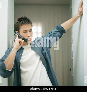 Man talking on cell phone in hallway Banque D'Images