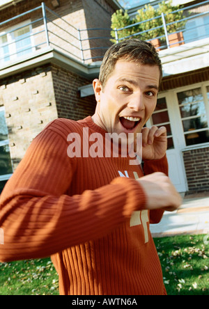 Man standing in front of house, à la surprise Banque D'Images