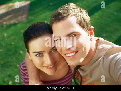 Couple smiling at camera, bras de l'homme autour de l'épaule de femme Banque D'Images