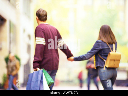 Couple shopping ensemble, se tenir la main, vue de derrière. Banque D'Images