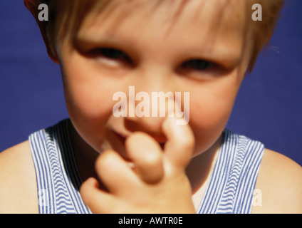 Enfant avec doigt dans le nez, close-up Banque D'Images