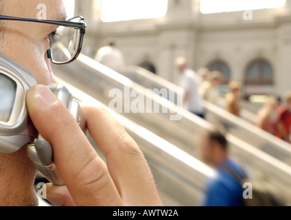 Man using cell phone in train station, close-up Banque D'Images