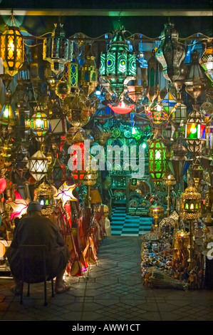 Close up vertical d'un commerçant à l'extérieur de ses magasins de vente de feux et lanternes marocaines traditionnelles dans la nuit. Banque D'Images