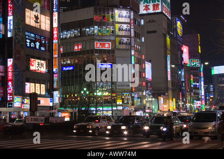 Scène de rue la nuit bien remplie avec de nombreux signes rougeoyant lumineux sur les bâtiments le long du temple Yasukuni Dori dans Shinjuku Tokyo Japon Banque D'Images