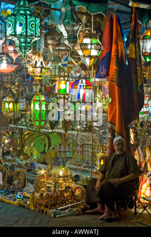 Close up vertical d'un commerçant à l'extérieur de ses magasins de vente de feux et lanternes marocaines traditionnelles dans la nuit. Banque D'Images