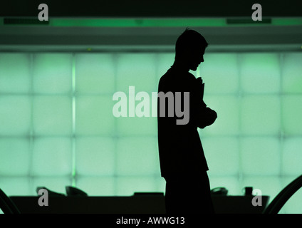 Homme debout devant les fenêtres, silhouette Banque D'Images