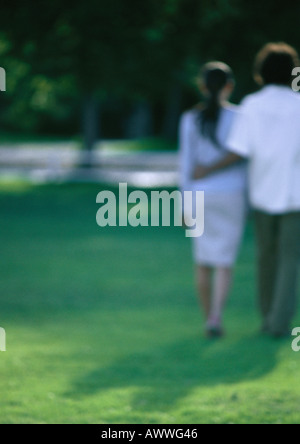 Jeune couple, le bras autour de la taille, à marcher ensemble, vue de derrière, blurred Banque D'Images