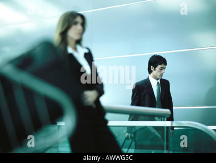 Businessman and businesswoman standing, avant-plan flou Banque D'Images