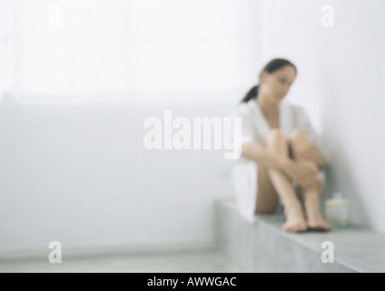 Femme assise au coin avec genoux, blurred Banque D'Images