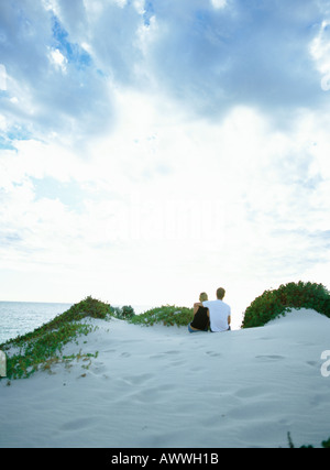 Couple sur dune de sable donnant sur la mer, vue arrière Banque D'Images