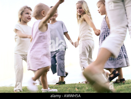 Les enfants se tenant la main, marchant dans l'anneau Banque D'Images