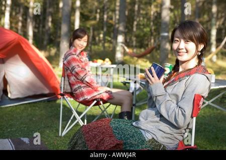 Portrait of teenage girls camping, assis sur un transat Banque D'Images