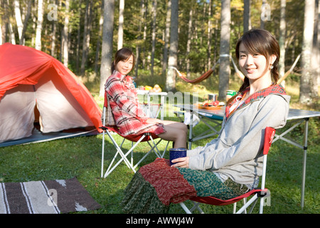 Portrait of teenage girls camping, assis sur un transat Banque D'Images