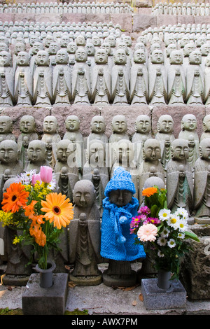 Rangées de statues jizo au Temple Hasedera soit mort-né ou bébés avortés, avec l'un vêtu d'une cape et un chapeau en tricot bleu Banque D'Images