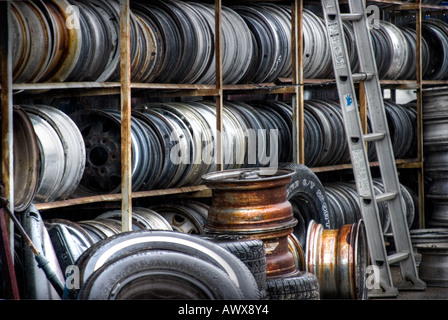 Jantes automobile rusty et brillant et pneus dans junkyard le long avec une échelle de couleur horizontale Banque D'Images