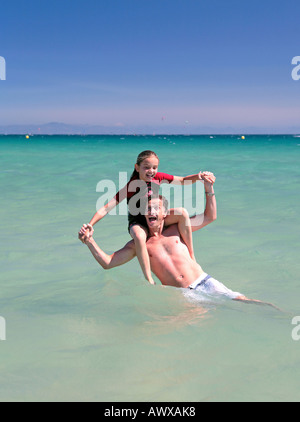 L'homme et fille rire et jouer dans la mer cristalline en vacances sur une belle journée ensoleillée Banque D'Images