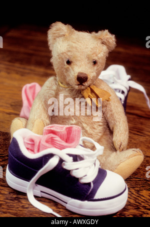 Ours en peluche vintage, jouet, baskets et chaussettes de petite taille. La nature morte de l'enfance. Souvenirs Banque D'Images