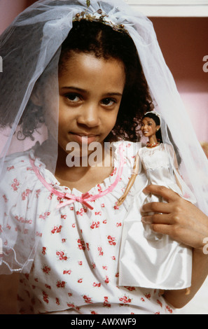 Little Black girl playing jeux mariage avec sa poupée Barbie. Banque D'Images