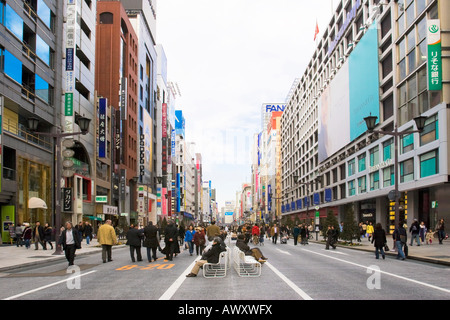 Les gens qui marchent et des commerces le long de l'avenue Chuo Dori le dimanche dans le quartier chic de Ginza de Tokyo Japon Banque D'Images