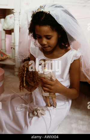Little Black girl playing jeux de mariage avec elle les poupées Barbie. Banque D'Images