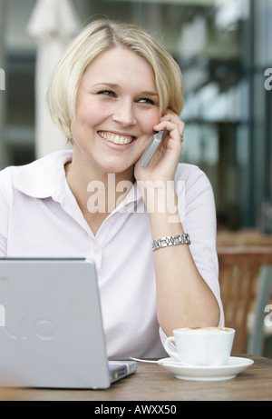 Jeune femme d'affaires dans un café avec un ordinateur portable Banque D'Images