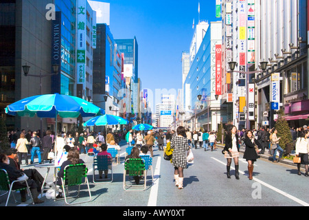 Les gens qui marchent et des commerces le long de l'avenue Chuo Dori le dimanche dans le quartier chic de Ginza de Tokyo Japon Banque D'Images