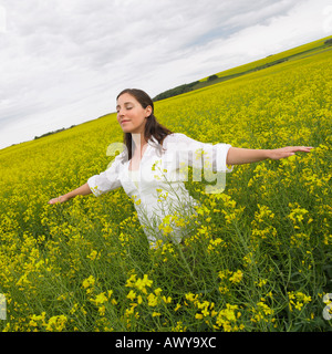 Femme Debout dans champ de canola, Alberta, Canada Banque D'Images