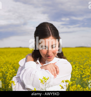 Femme Debout dans champ de canola, Alberta, Canada Banque D'Images