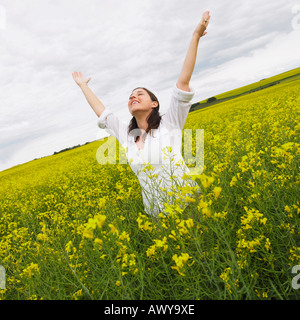 Femme Debout dans champ de canola, Alberta, Canada Banque D'Images